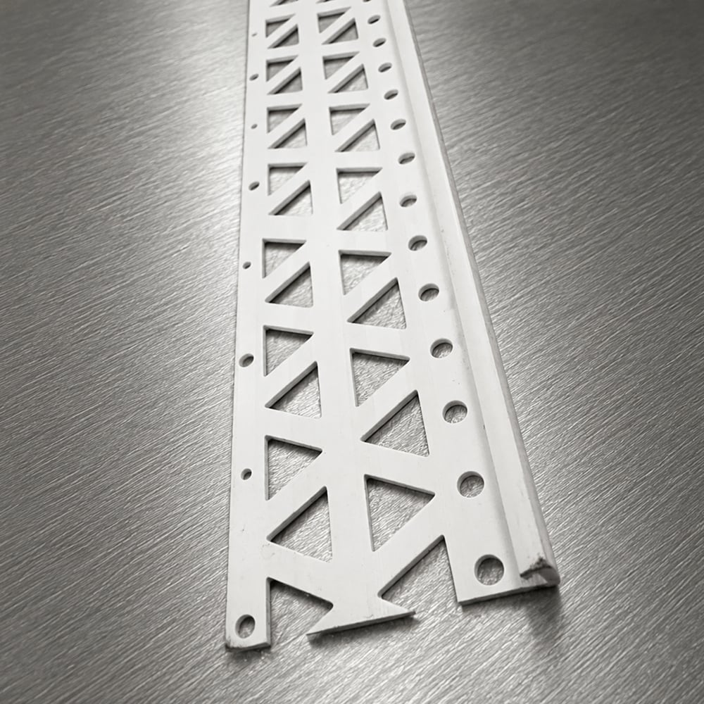Plaster Stop – uPVC_6mm White uPVC plaster stop bead with triangular perforated wing on a brushed metal background.