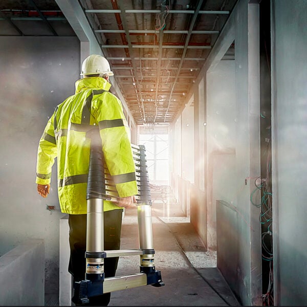 Telescopic ladder being carried by a construction worker on site