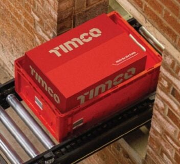 TIMCO product box in a red delivery crate travelling along a warehouse conveyor system